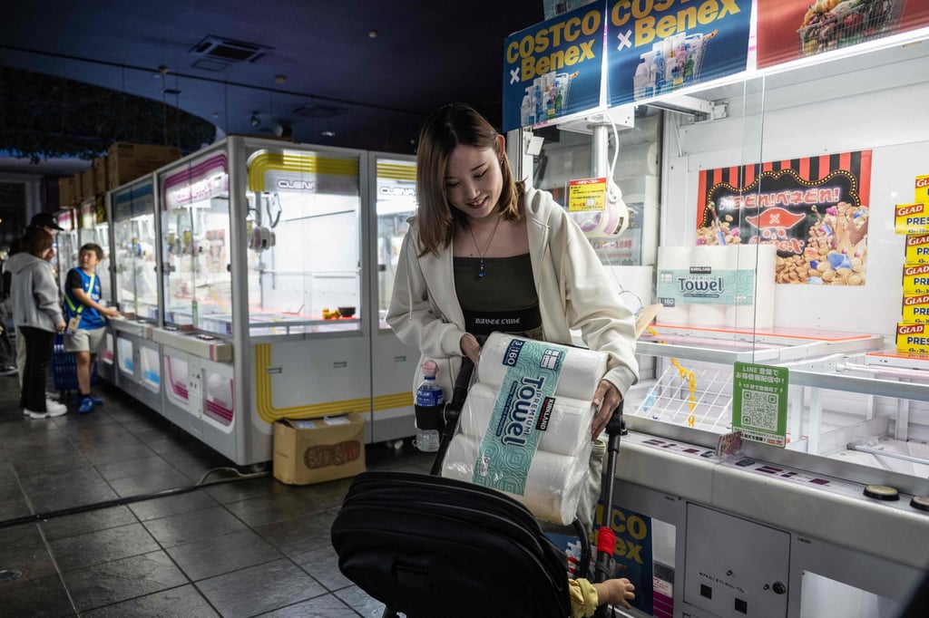 A woman organises a pack of paper towels she won at a claw machine game in Kawasaki on October 5. Photo: AFP