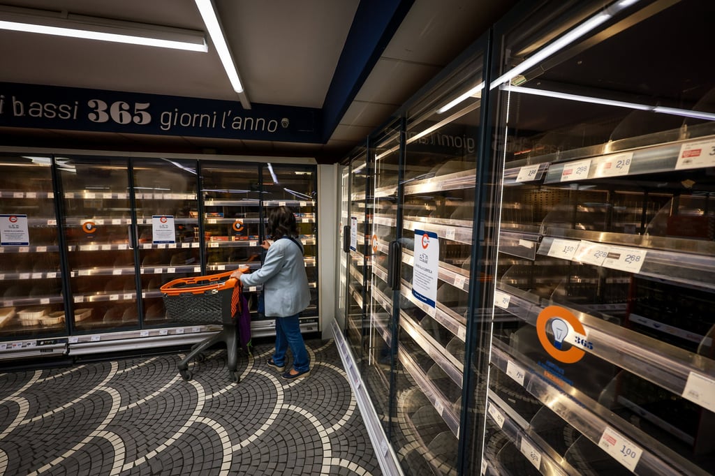 A woman looks at empty shelves in a supermarket in Naples, Italy, on Thursday. Photo: LaPresse via AP