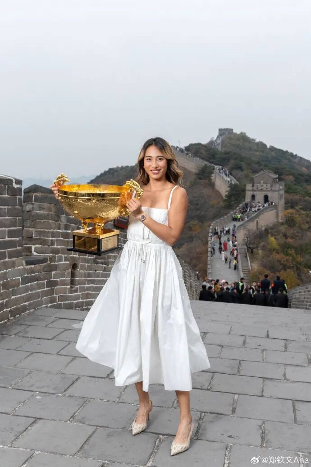 Chinese tennis star Zheng Qinwen faces online criticism after posing with her China Open trophy on the Great Wall in a white dress and high heels. Photo: Weibo