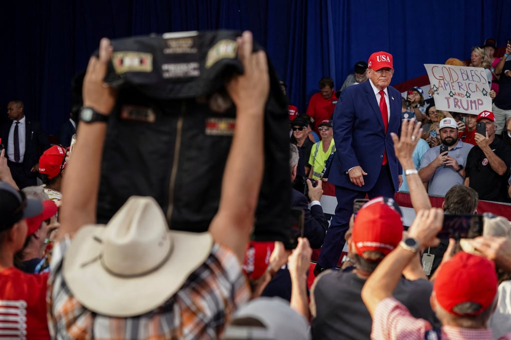 A man holds up a jacket as US President Donald Trump leaves a campaign event in Dalton, Georgia, on October 16. Photo: Reuters A man holds up a jacket as US President Donald Trump leaves a campaign event in Dalton, Georgia, on October 16. Photo: Reuters