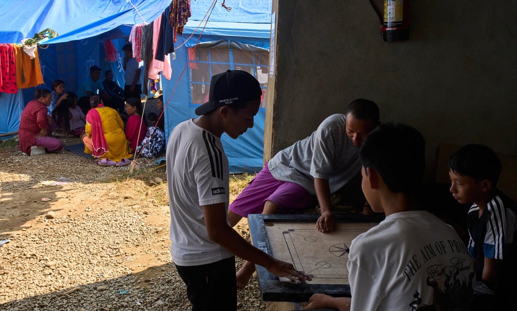 Survivors of the Nepal flash floods in August play a game of carrom at a temporary holding centre in Nuwakot district on October 2. Photo: AP