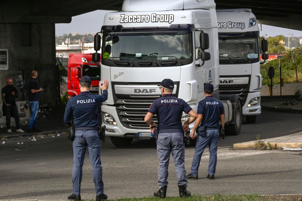 Police officers stop trucks during a slow-moving protest in Naples, Italy, on Thursday. Photo: EPA