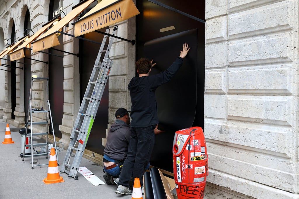 Workers install panels to protect the storefront windows of a Louis Vuitton store in Lyon, ahead of nationwide protests against the cost of living and rising fuel prices in France, on Friday. Photo: Reuters Workers install panels to protect the storefront windows of a Louis Vuitton store in Lyon, ahead of nationwide protests against the cost of living and rising fuel prices in France, on Friday. Photo: Reuters