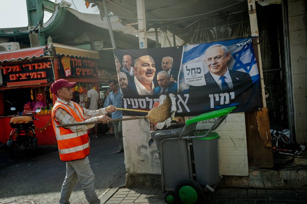 A municipal street cleaner empties a broom into a mobile trash bin in front of a Likud party campaign banner showing Israeli Prime Minister Benjamin Netanyahu at HaTikva Market in Tel Aviv. Photo: dpa A municipal street cleaner empties a broom into a mobile trash bin in front of a Likud party campaign banner showing Israeli Prime Minister Benjamin Netanyahu at HaTikva Market in Tel Aviv. Photo: dpa
