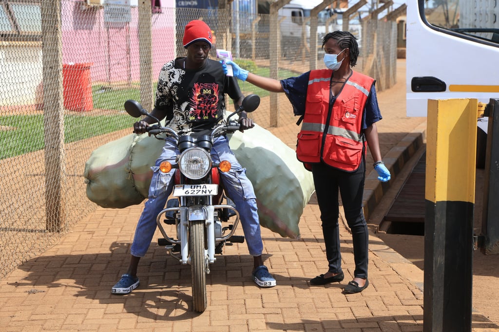 A Kenyan health worker checks the temperatures of travellers crossing from Uganda to Kenya as part of measures to contain the spread of Ebola virus in Busia, Kenya, on October 15. Photo: AP A Kenyan health worker checks the temperatures of travellers crossing from Uganda to Kenya as part of measures to contain the spread of Ebola virus in Busia, Kenya, on October 15. Photo: AP