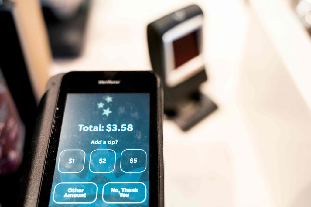 Tip options are displayed on a credit card reader at a store in Washington on March 17, 2023. Photo: AFP