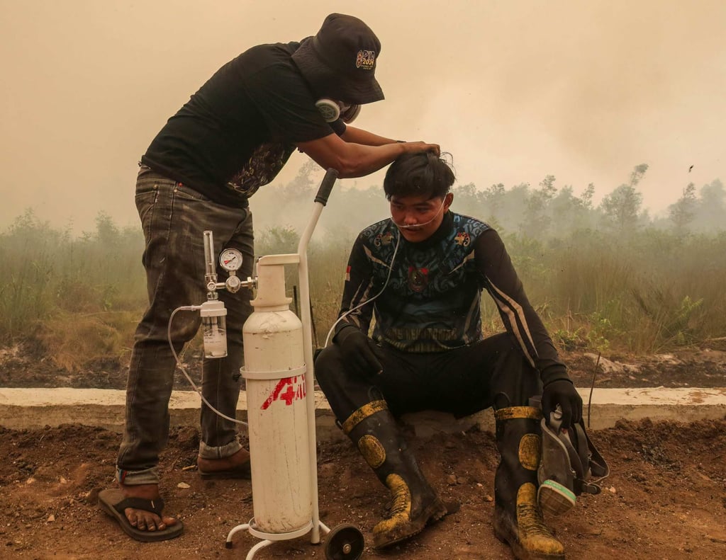 A volunteer provides mobile oxygen relief to a firefighter battling forest and land fires in Palangka Raya, Central Kalimantan, on Thursday. Photo: AFP