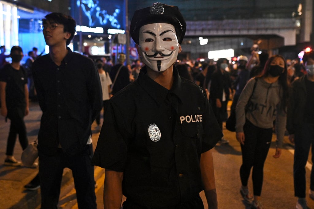 A man dressed in a police uniform stands on a street in Hong Kong during Halloween in 2019. Photo: AFP