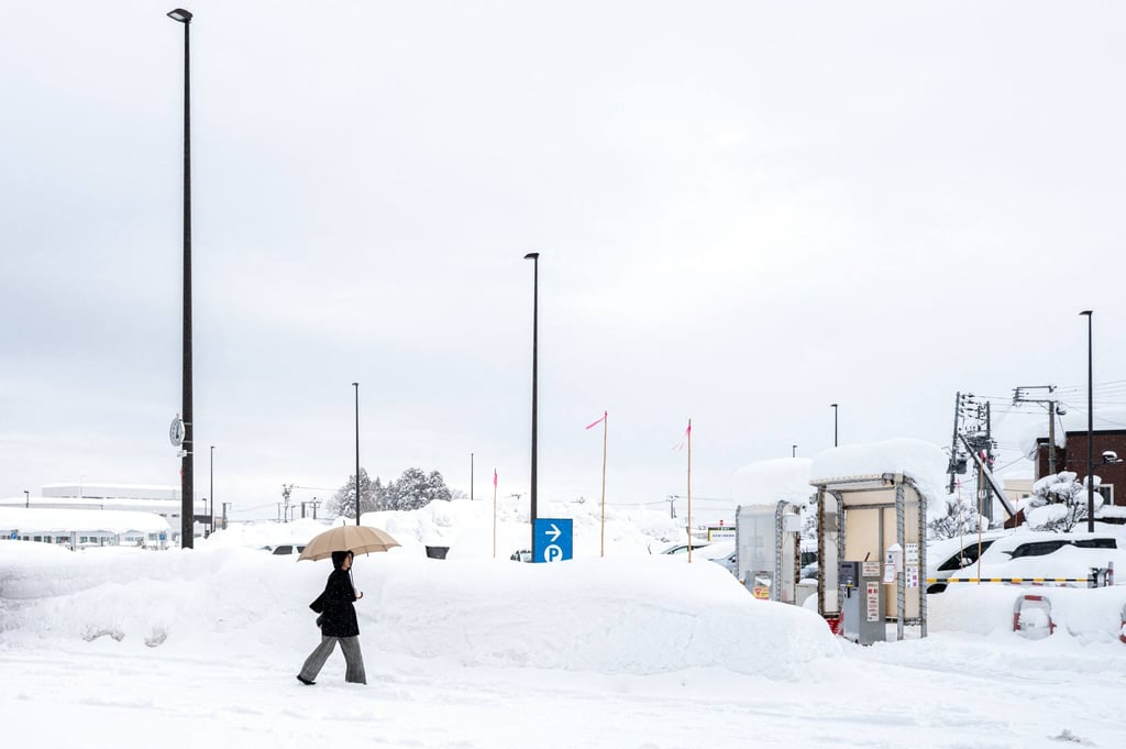A pedestrian walks towards a snow-covered car park in Aomori city, Japan, in January. Photo: AFP A pedestrian walks towards a snow-covered car park in Aomori city, Japan, in January. Photo: AFP