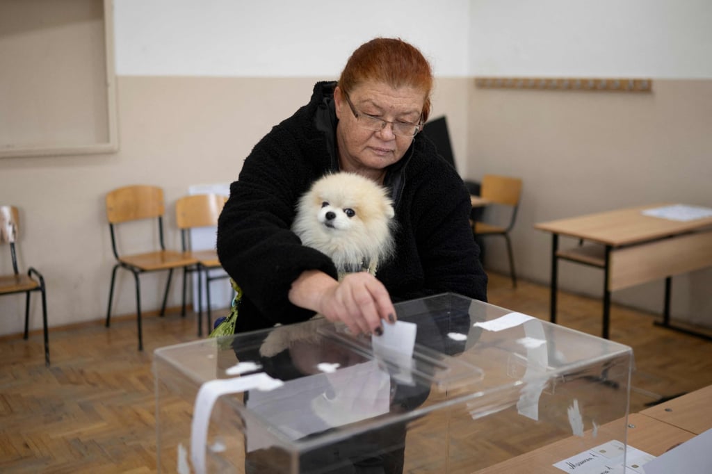 A woman holding a dog arrives to place a ballot at a polling station in Sofia, Bulgaria on Sunday. Photo: AFP A woman holding a dog arrives to place a ballot at a polling station in Sofia, Bulgaria on Sunday. Photo: AFP