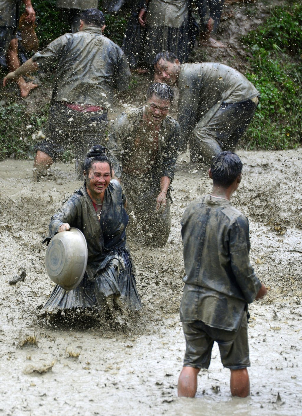 Miao villagers splash mud water in a paddy field to pray for rain during a traditional folk festival in Jiaobang village, Jianhe county. Photo: Visual China Group via Getty Images