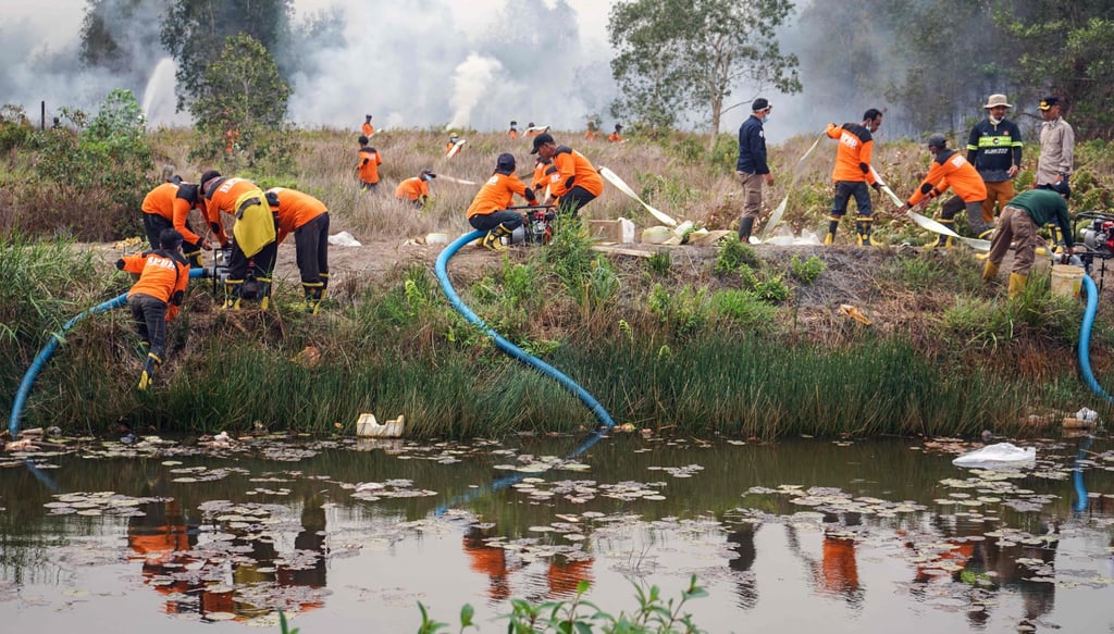 Indonesian firefighters pump water to extinguish spreading wildfires amid dense smoke and haze in Barito Kuala, South Kalimantan province, on Sunday. Photo: AFP Indonesian firefighters pump water to extinguish spreading wildfires amid dense smoke and haze in Barito Kuala, South Kalimantan province, on Sunday. Photo: AFP