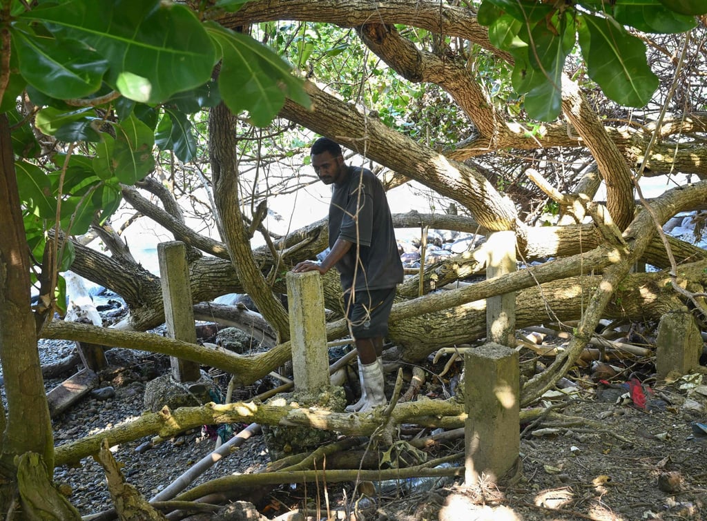 Serua Island resident Avenai Ranuku looks at the remains of a former home on October 9 after rising sea levels inundated the area and forced residents to abandon properties. Photo: AFP Serua Island resident Avenai Ranuku looks at the remains of a former home on October 9 after rising sea levels inundated the area and forced residents to abandon properties. Photo: AFP
