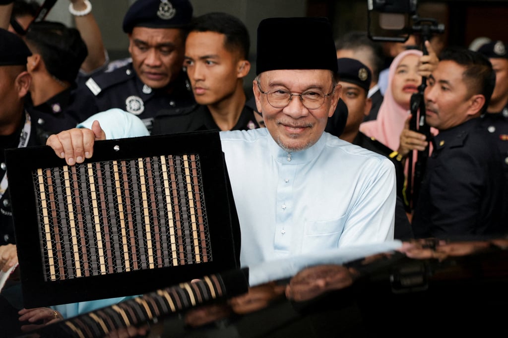 Malaysia’s Prime Minister and Finance Minister Anwar Ibrahim holds the 2027 national budget document as he departs for parliament to table the budget in Putrajaya on October 9. Photo: Reuters