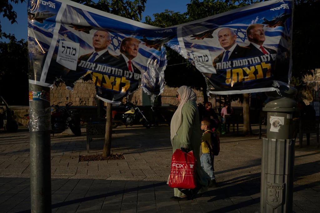 An Arab woman walks with a child next to a torn Likud party campaign ad featuring Israeli Prime Minister Benjamin Netanyahu and US President Donald Trump in Jerusalem on Wednesday. Photo: AP An Arab woman walks with a child next to a torn Likud party campaign ad featuring Israeli Prime Minister Benjamin Netanyahu and US President Donald Trump in Jerusalem on Wednesday. Photo: AP
