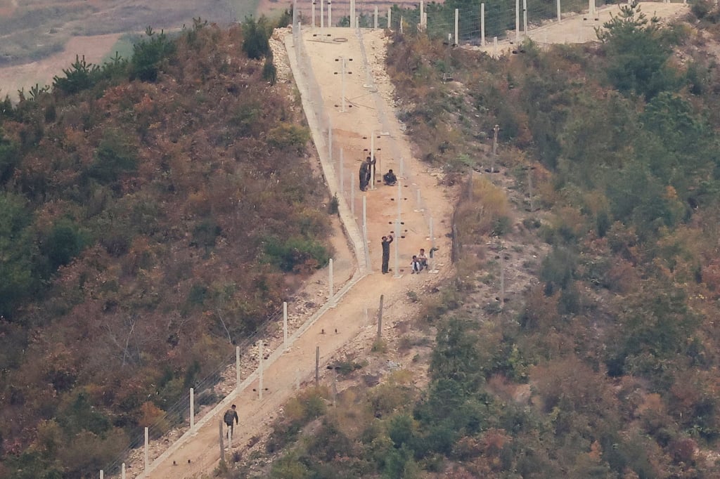 North Korean soldiers work on a barbed wire fence along their border on Monday. Photo: Reuters