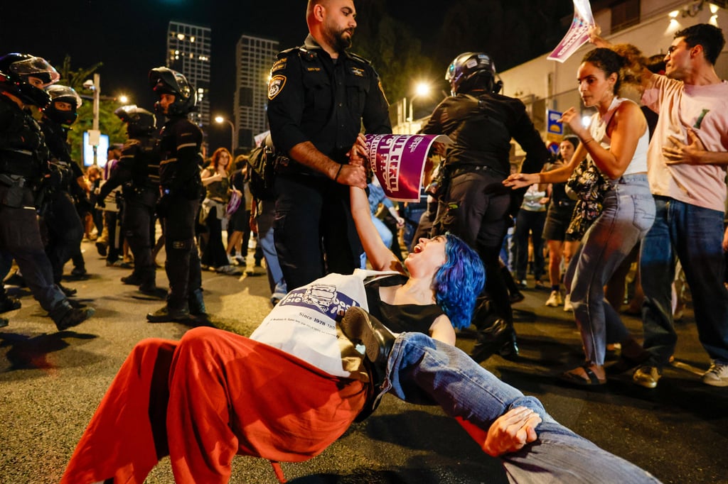 A police officer removes a protester from the road as she takes part in a rally in Tel Aviv on Wednesday demanding that Israel-Arab parties be included in the formation of the next government coalition. Photo: Reuters A police officer removes a protester from the road as she takes part in a rally in Tel Aviv on Wednesday demanding that Israel-Arab parties be included in the formation of the next government coalition. Photo: Reuters
