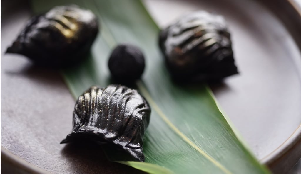 Steamed shrimp dumplings in bamboo charcoal wrapping with gold dust