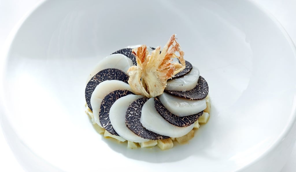 Warm sliced scallop on a bed of baby artichoke and black truffle