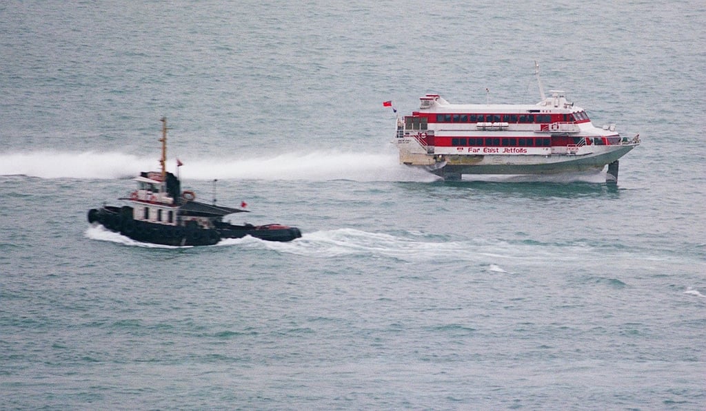 A Far East Jetfoil, inbound from Macau, speeds past a tug boat off of the dock in Kennedy Town. Photo: SCMP Pictures