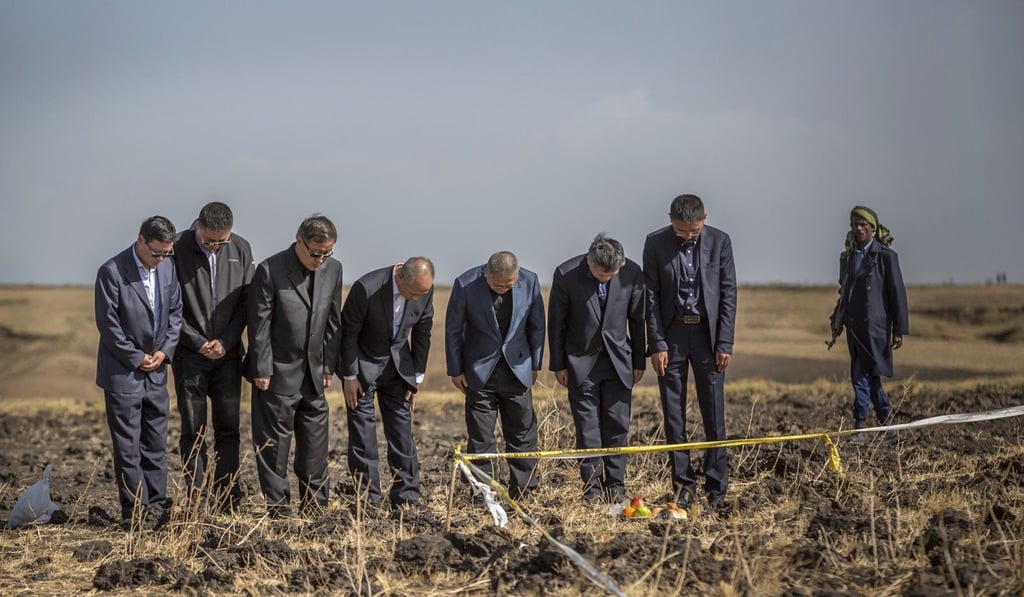Officials from the Aviation Industry Corporation of China (AVIC) pray at the scene where the Ethiopian Airlines Boeing 737 MAX 8 crashed. Photo: AP Officials from the Aviation Industry Corporation of China (AVIC) pray at the scene where the Ethiopian Airlines Boeing 737 MAX 8 crashed. Photo: AP