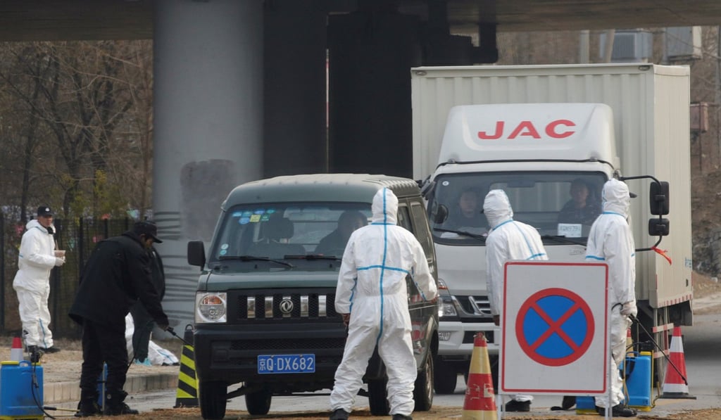 Workers in protective suits at a checkpoint on a road leading to a village near a farm where African swine fever was detected, in Fangshan district of Beijing, China, in November. Photo: Reuters