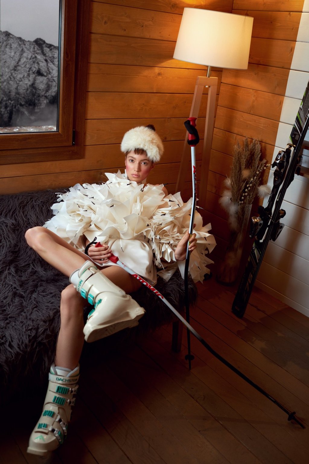 Alexandre Vauthier Haute Couture white satin bustier dress with silk organza flowers and coq feathers; Peauluxe headpiece; Atomic ski poles; Dachstein ski boots; Rossignol skis