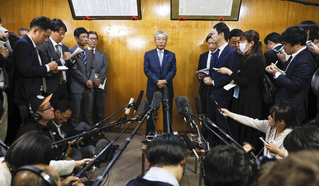Takeda talks to journalists after announcing his resignation. Photo: EPA