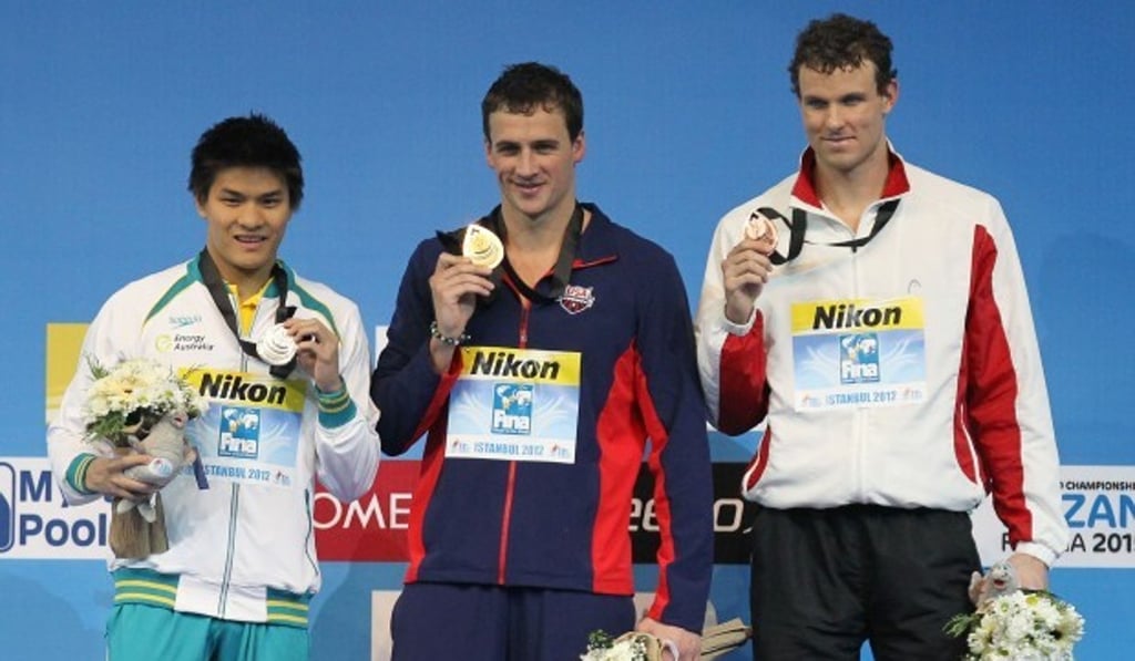 Ryan Lochte (centre) and Kenneth To (left) on the podium at the 2012 Short Course Swimming World Championships. Photo: AP