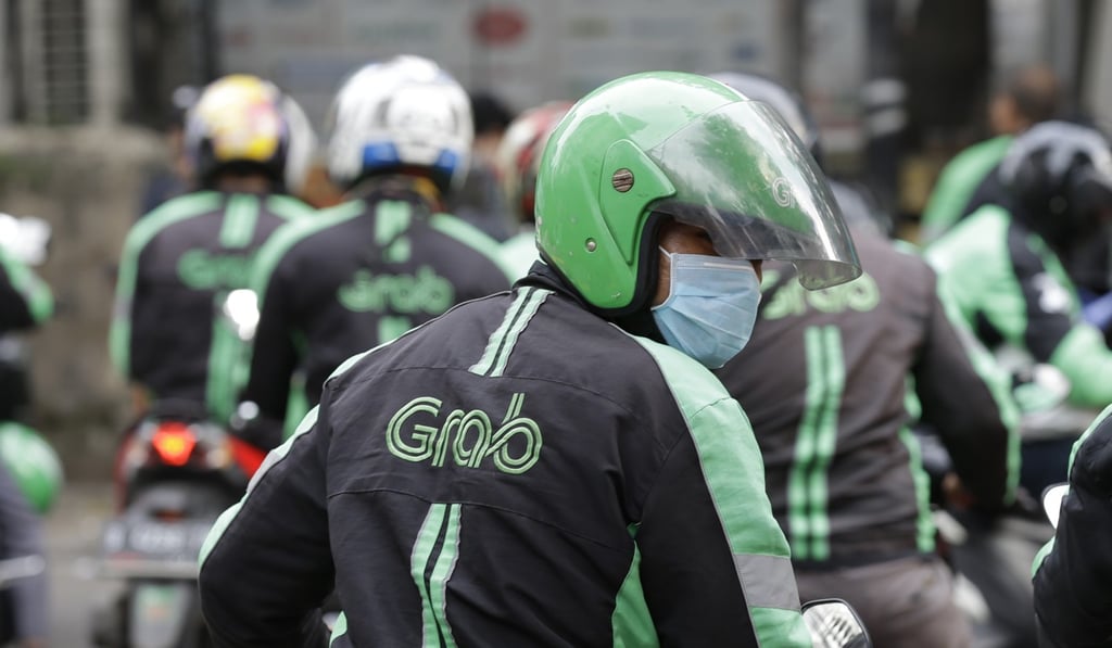 A GrabBike driver rides on his motorbike in Jakarta, Indonesia, Tuesday, March 13, 2018. Southeast Asian ride hailing app Grab is expanding into financial services in partnership with a Japanese credit card company, hoping to offer credit to millions of people without bank accounts. Photo: AP