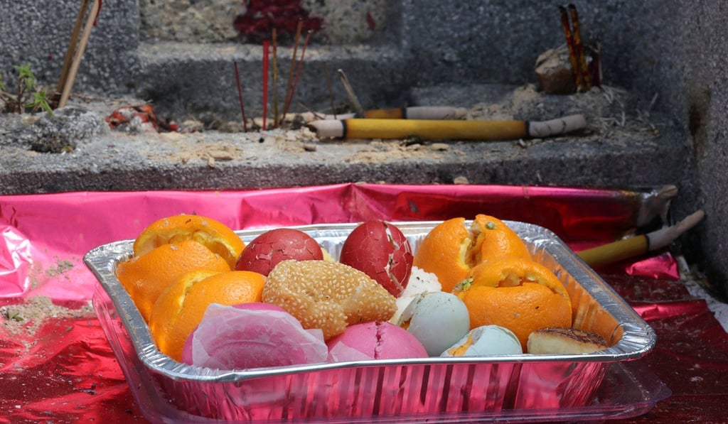 Food offerings are placed on a tombstone at the Diamond Hill Cemetery, during the Ching Ming grave-sweeping festival in April last year. Photo: Felix Wong