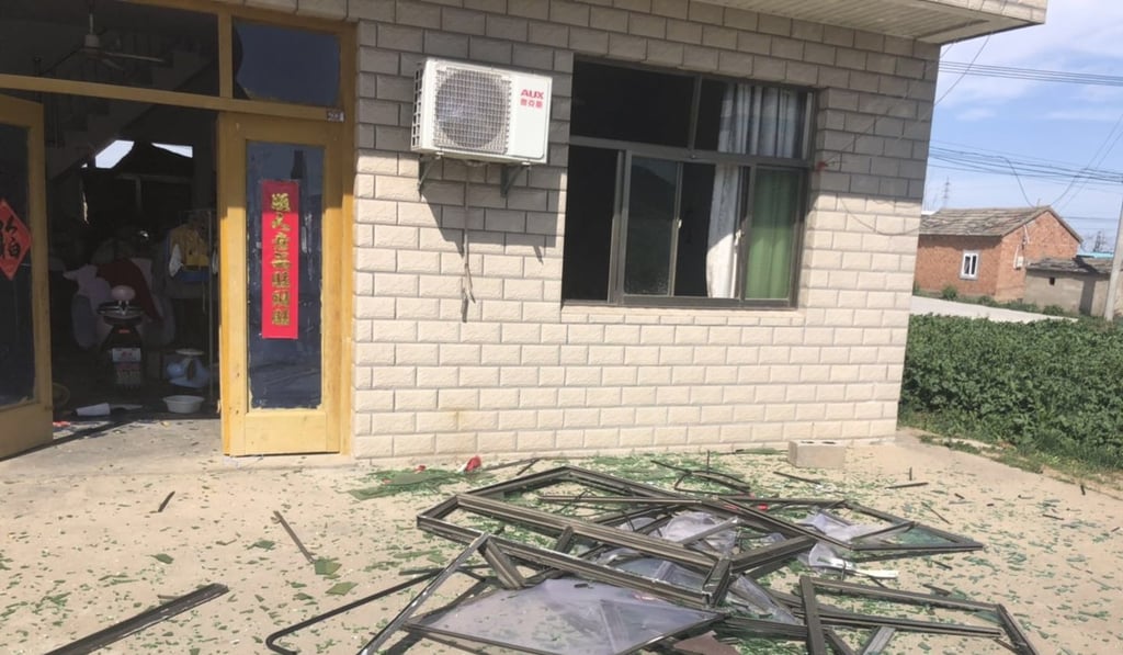 Shattered glass outside a home in a nearby village. Photo: Sidney Leng