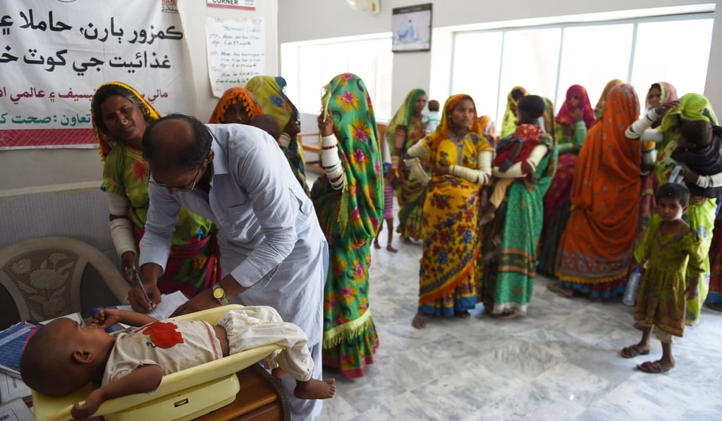 A Pakistani paramedic weighs a child at Mithi Civil Hospital. Photo: AFP A Pakistani paramedic weighs a child at Mithi Civil Hospital. Photo: AFP