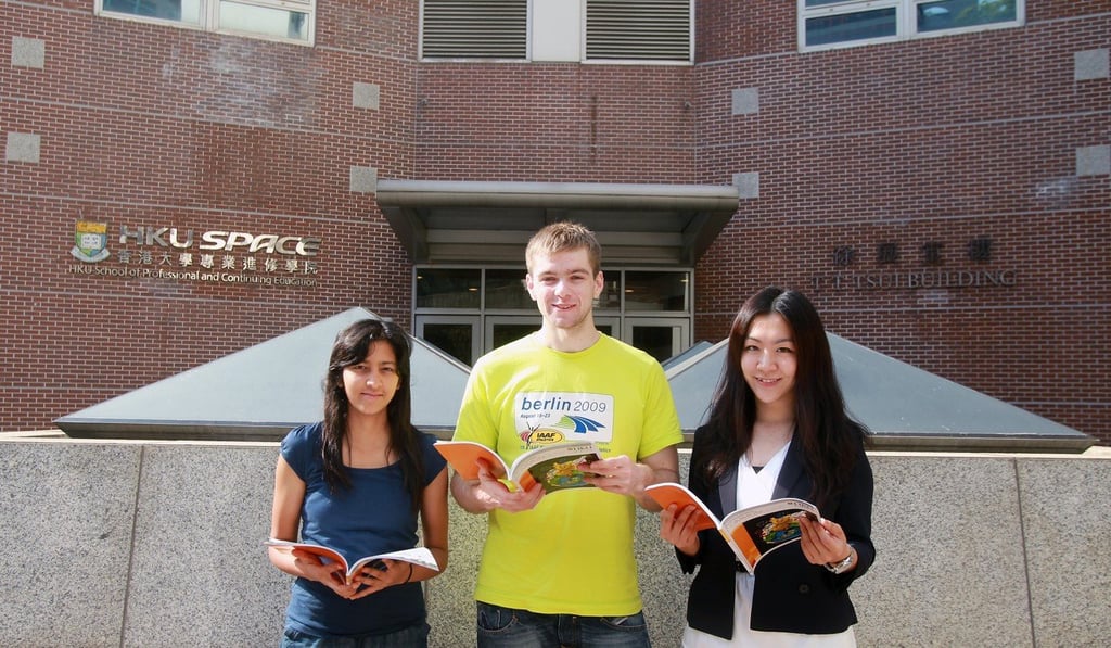 International students pose with the University of Hong Kong brochure in April 2011. While the university has done much to attract international students, housing can be a challenge. Photo: Jonathan Wong