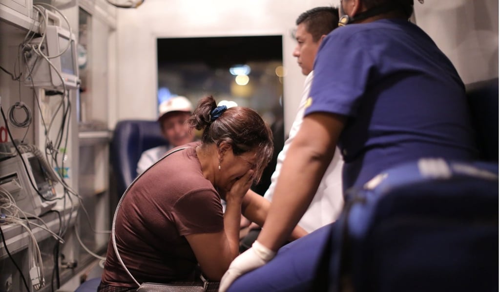 A woman cries while being checked by paramedics outside the bus station on March 31, 2019. Photo: AFP