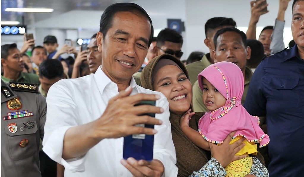 Indonesian President Joko Widodo takes a picture with a woman and her child in Jakarta. Photo: AFP Indonesian President Joko Widodo takes a picture with a woman and her child in Jakarta. Photo: AFP