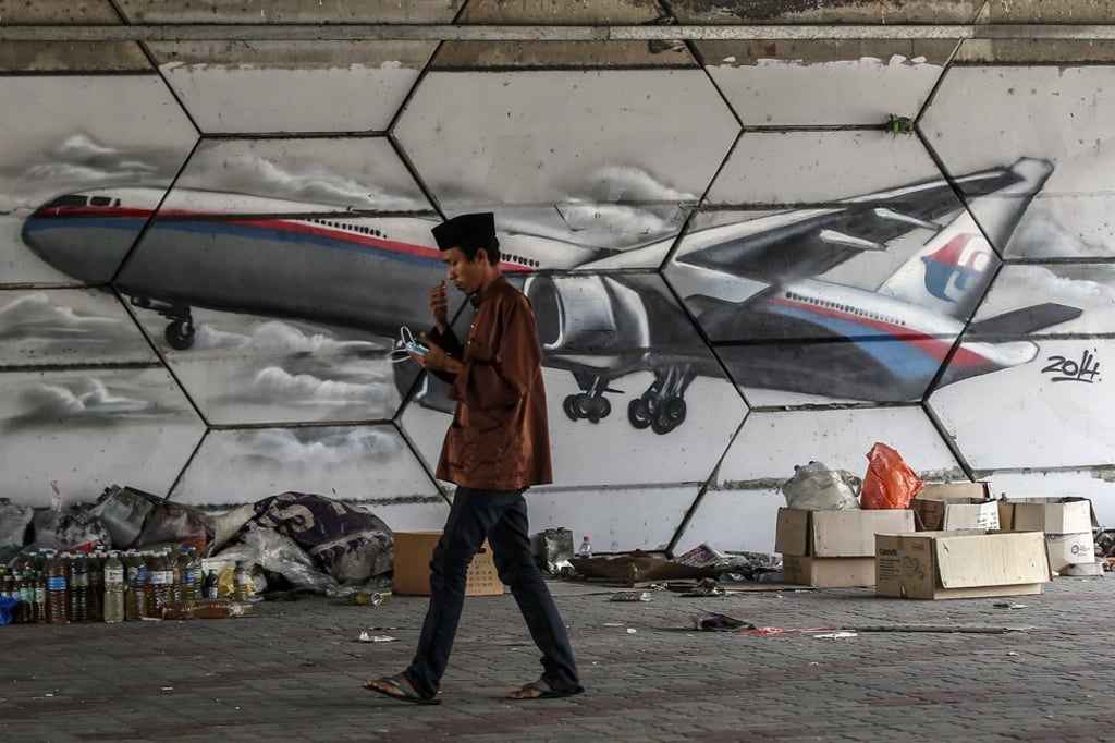A man passes a mural of Malaysia Airlines flight MH370 at Ampang, outside Kuala Lumpur. Photo: EPA