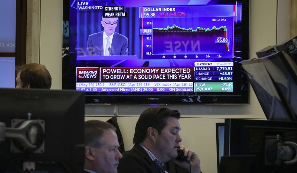 Traders work on the floor of the New York Stock Exchange as a monitor features Federal Reserve chairman Jerome Powell announcing that the central bank will leave rates unchanged on March 20. Photo: AFP