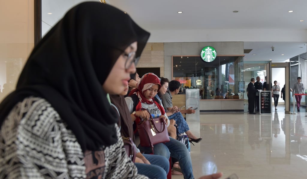 Indonesian Muslim women outside a Starbucks cafe at a shopping mall in Jakarta. The chain has been subject to boycotts by Muslim groups in the past. Photo: AFP