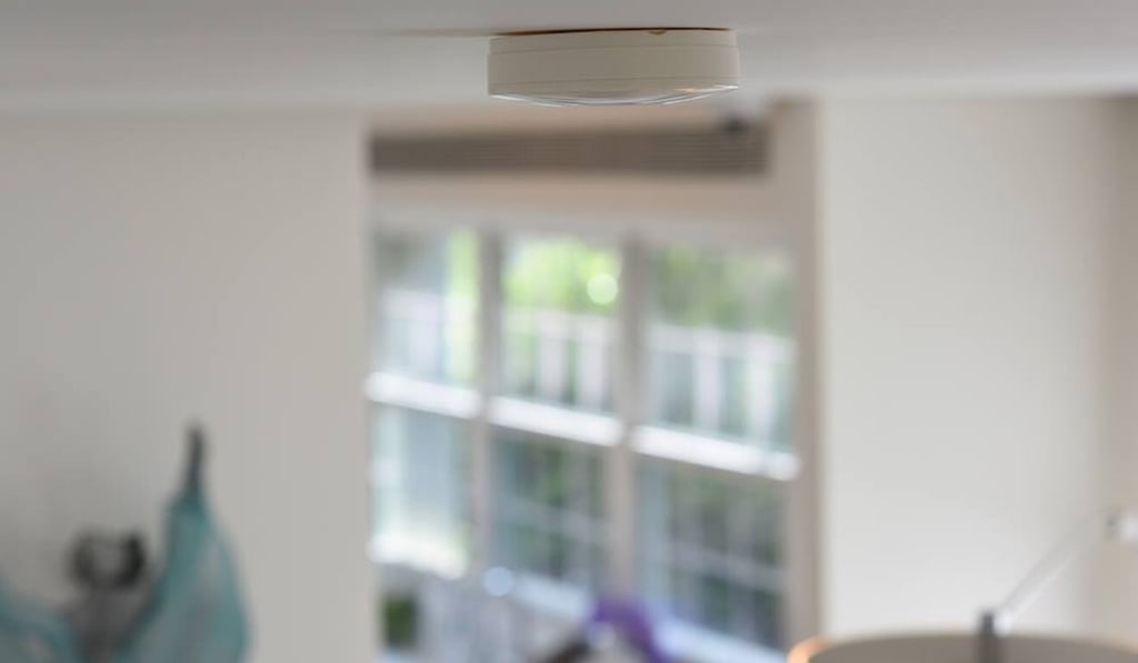 The RoomMe ceiling-mounted device, which looks similar to a smoke detector, can detect a person’s presence via their smartphone and automatically change room settings according to their preferences. Photo: Intellithings