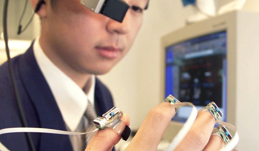 Olympus Optical researcher Hidekazu Iwaki demonstrates the company's new human interface device for wearable personal computer at its technology exhibition in Tokyo. Photo: Toshiyuki Aizawa / Reuters