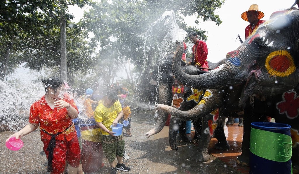 A Thai mahout on an elephant spraying water on revellers. Photo: EPA A Thai mahout on an elephant spraying water on revellers. Photo: EPA