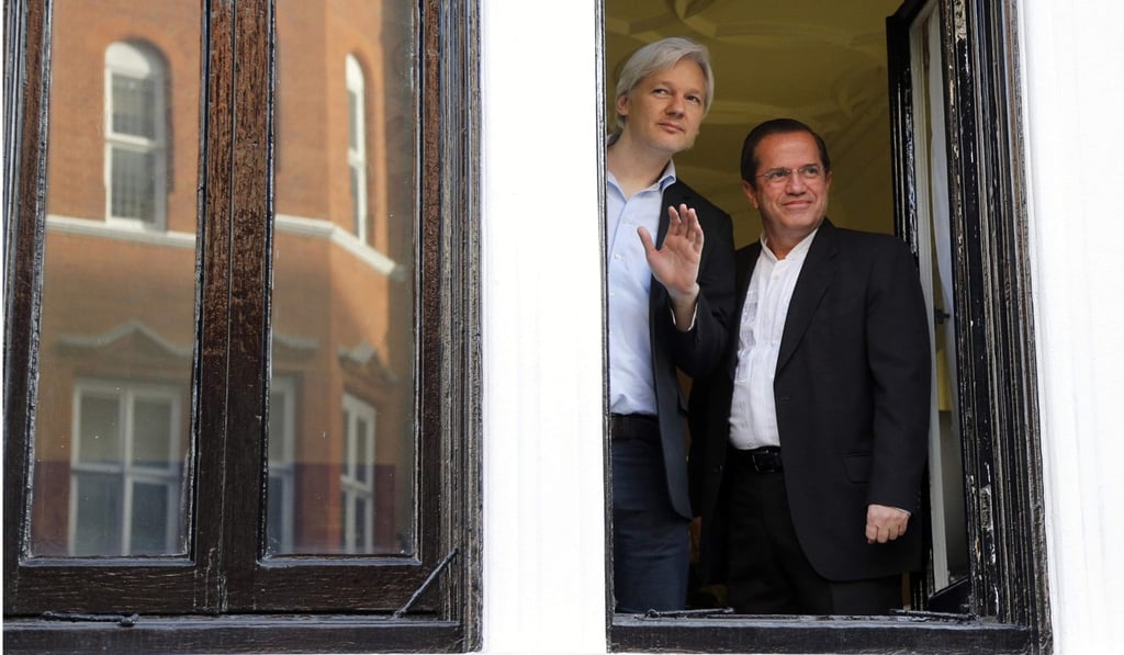 WikiLeaks founder Julian Assange waves from a window at Ecuador’s embassy in London with Ecuador’s foreign minister at the time Ricardo Patino on June 16, 2013. Photo: Reuters