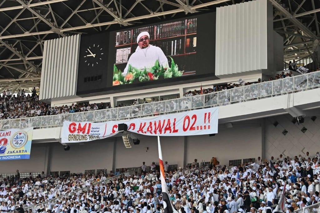Habib Rizieq Shihab, head of the Islamic Defender’s Front, is seen on a screen at a rally for Probowo Subianto on April 7. Photo: AFP