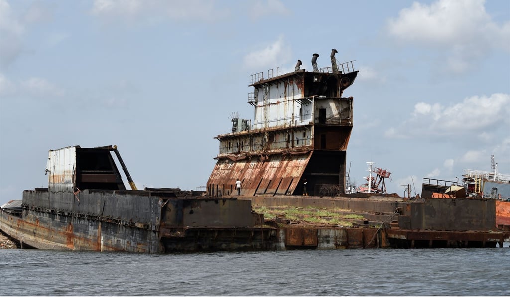 A man walks on an abandoned shipwreck in Lagos’ waterways on April 8, 2019. Photo: AFP