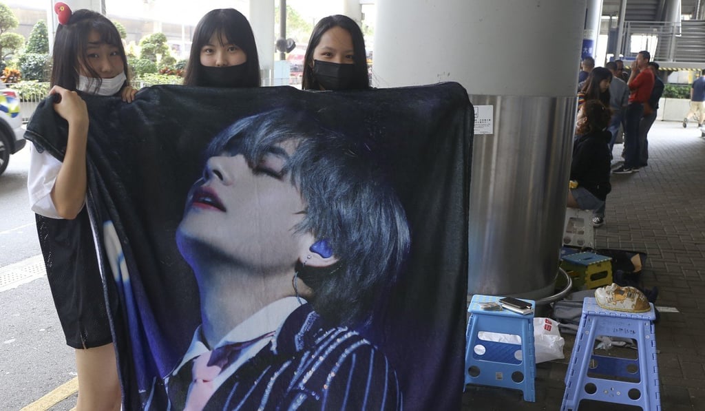 The three girls in Hong Kong holding a towel printed with the face of V, a member of BTS. Photo: SCMP