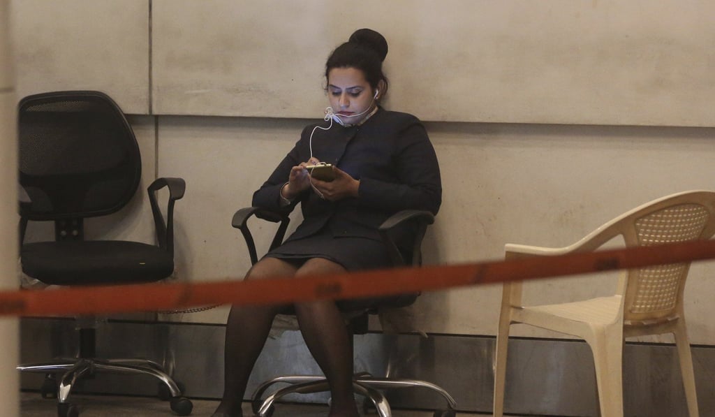 An employee of Jet airways checks her phone as she sits outside their ticketing counter at Chhatrapati Shivaji Maharaj International Airport in Mumbai. Photo: AP An employee of Jet airways checks her phone as she sits outside their ticketing counter at Chhatrapati Shivaji Maharaj International Airport in Mumbai. Photo: AP