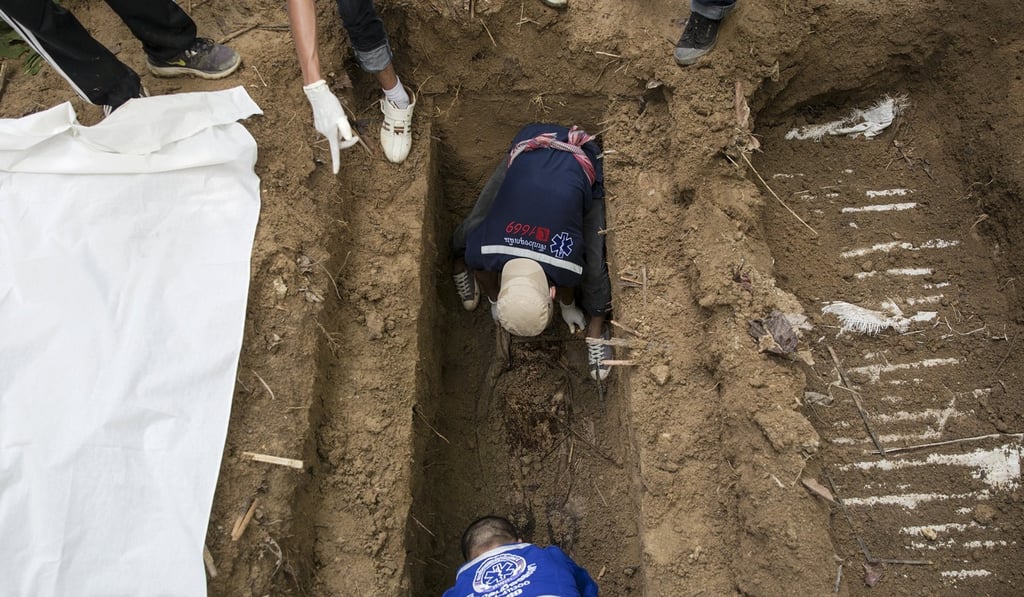 Human remains are retrieved from a mass grave at an abandoned camp in a jungle some three hundred meters from the border with Malaysia, in Thailand's southern Songkhla province May 2, 2015. Photo: Reuters