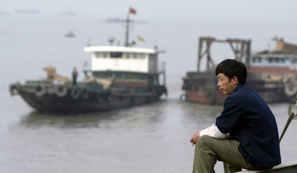 A Chinese worker sits on the bank of the Yangtze River in Nanjing. The Yangtze Delta is one of China’s three emission control areas required to meet the 0.5 per cent maximum sulphur fuel standard ahead of the International Maritime Organisation mandate. Photo: EPA