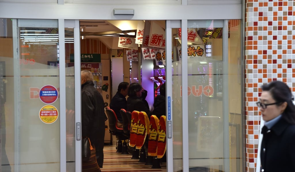 A woman walks in front of a pachinko parlour in Tokyo. Photo: AFP